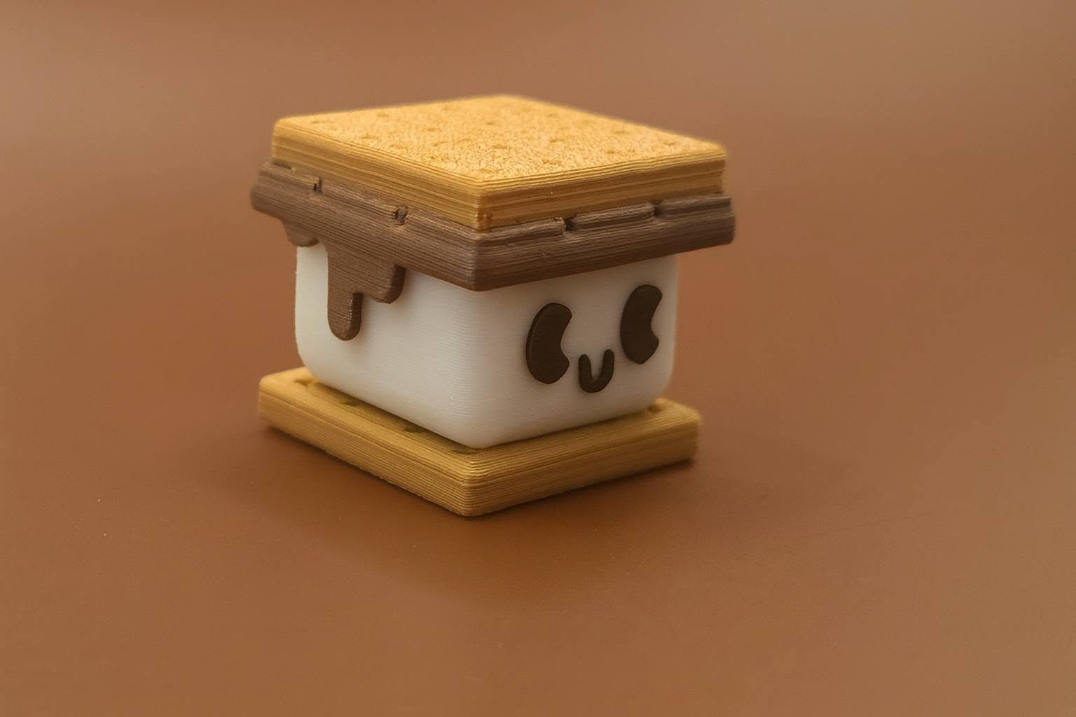 3D printed s'more fidget keyring with a happy marshmallow face and chocolate drip